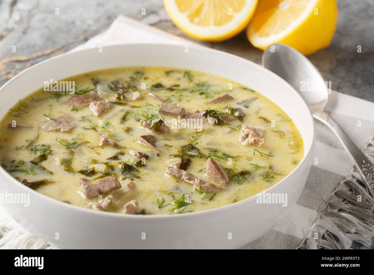 Magiritsa ist eine griechische Suppe aus Lammabfällen, die mit der Ostertradition in einer Schüssel auf einem Marmortisch in Verbindung gebracht wird. Horizontal Stockfoto