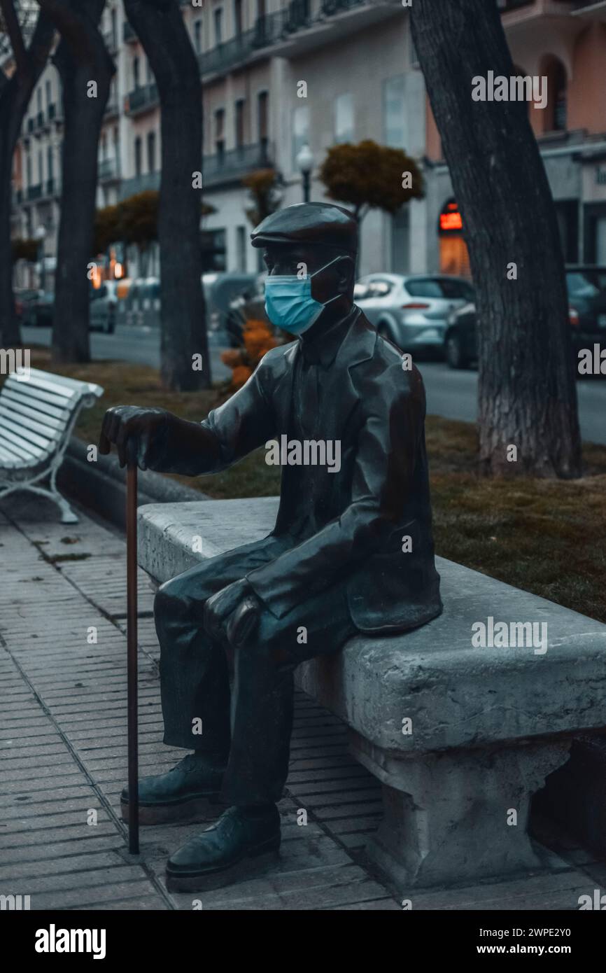 Statue der älteren Virgili auf der Rambla Nova in Tarragona, mit einer Maske wegen COVID-19. Stockfoto