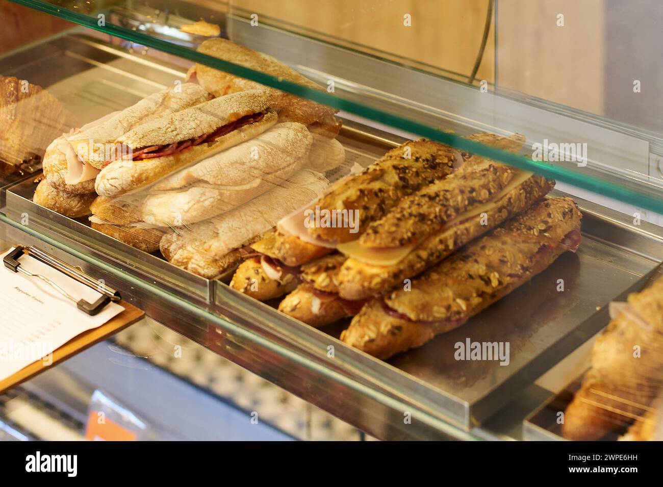 Appetitliche handwerkliche Sandwiches, die in einer Delikatessenvitrine verkauft werden können. Stockfoto