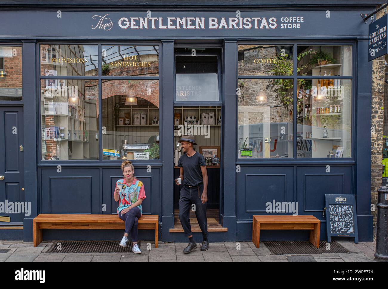 Männliche und weibliche Freunde trinken Kaffee vor dem Café Stockfoto