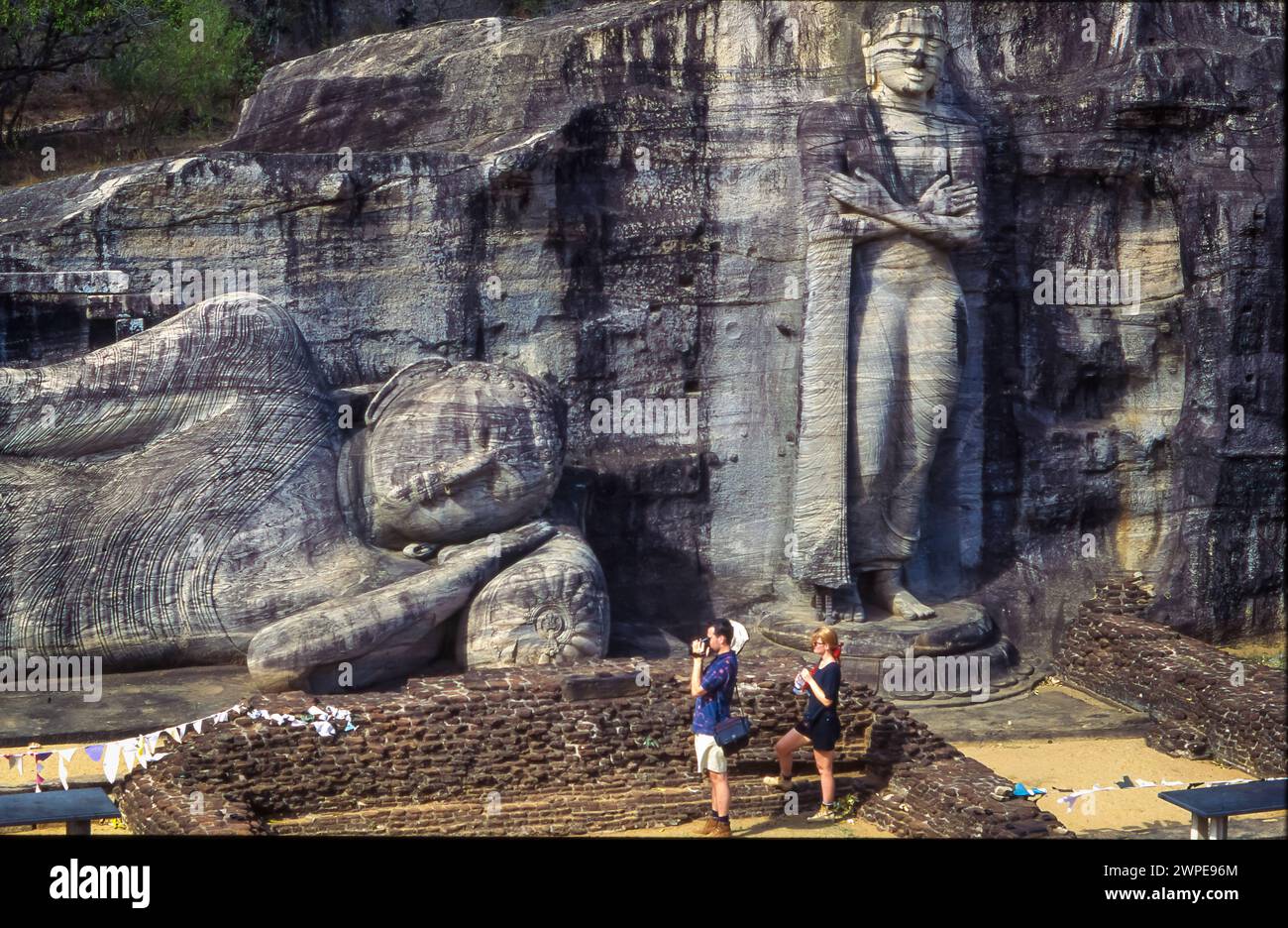 Sri Lanka, Touristen im 'Gal Vihara', dem stehenden und liegenden Buddha in Polonnaruwa. Stockfoto