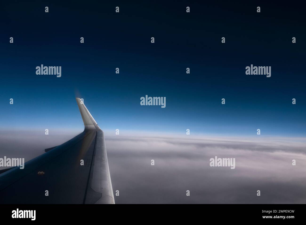 Flugzeugflügel in großer Höhe gegen klaren und bewölkten blauen Himmel. Nützliches horizontales Banner Stockfoto
