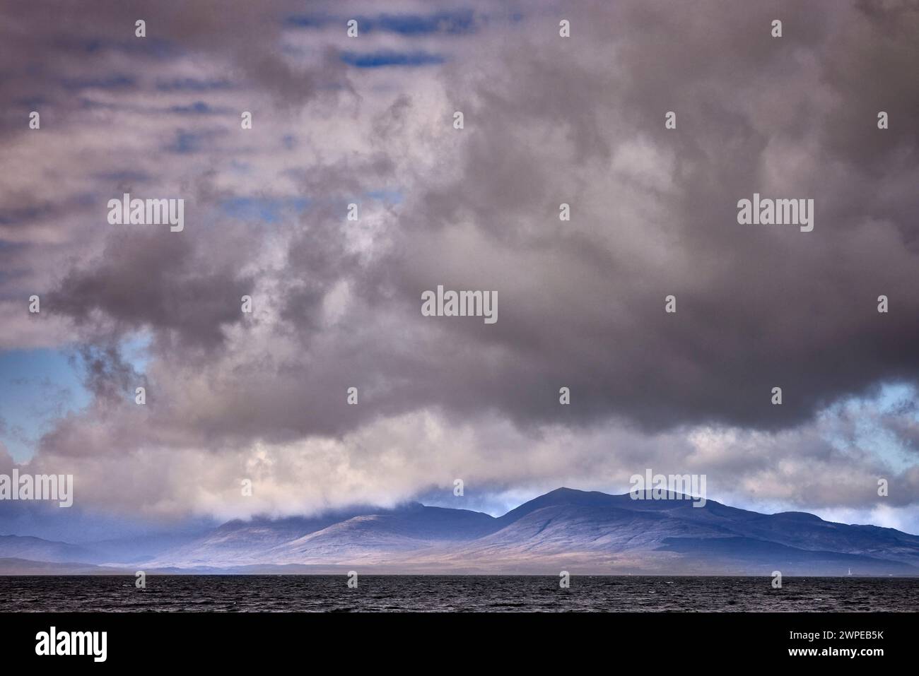 Unter einem schweren und unheimlichen Himmel taucht Mull durch den Nebel von Ganavan Sands von Oban auf. Schottland Stockfoto