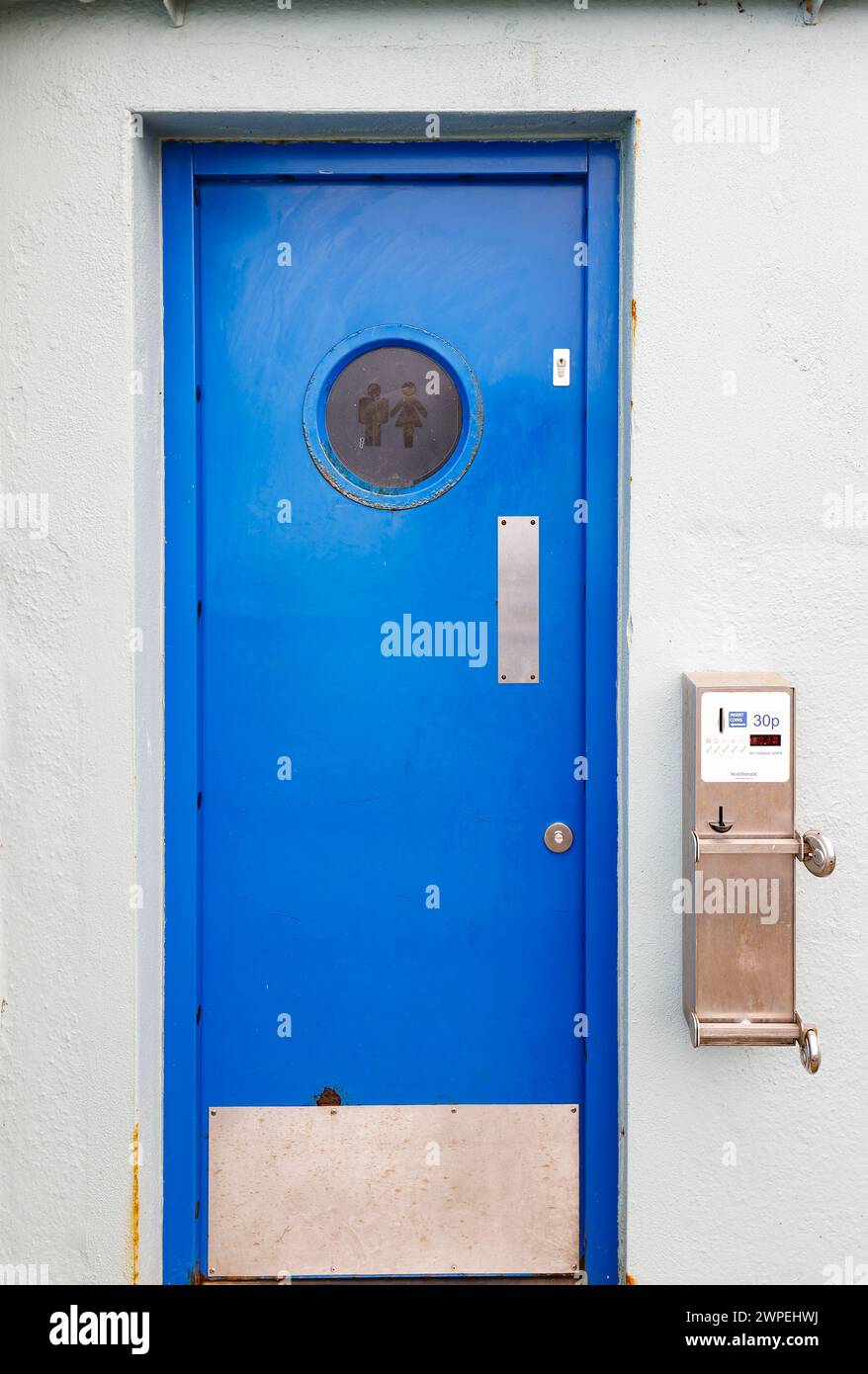 Öffentliche Toiletten mit einem Mindestpreis von 30 Pence statt eines Penny in Blue mit Fingerplatte, Münzautomat und kreisförmigem Gravurfenster Stockfoto