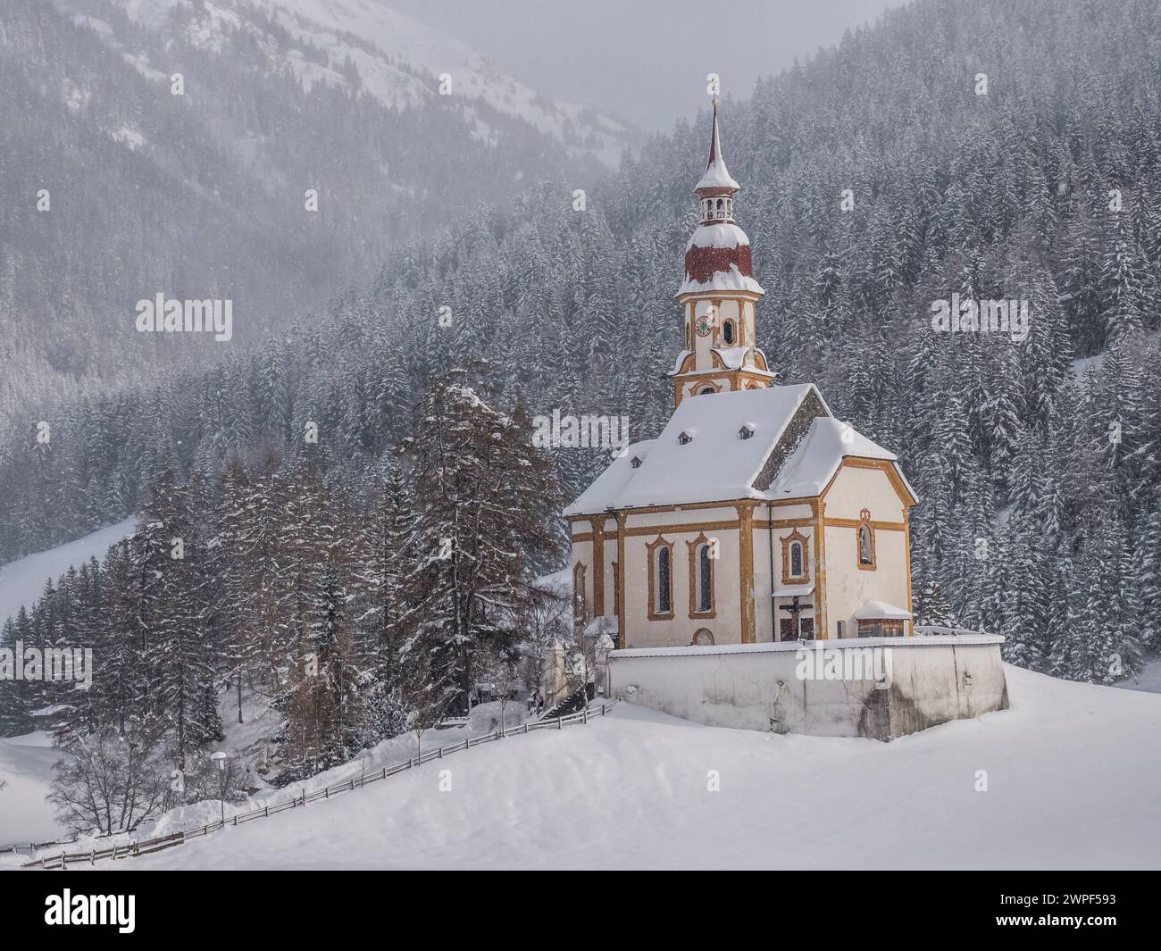 Dieses Winterbild zeigt die Nikolaikirche im Dorf Obernberg am Kopf des Obernbergtals im österreichischen Tirol Stockfoto