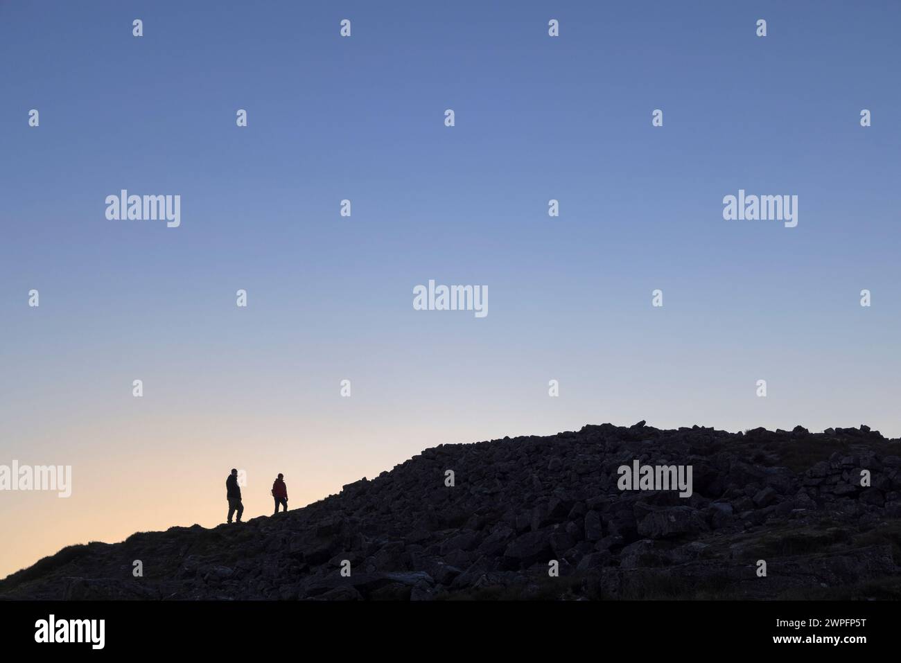 Zwei Wanderer mit Silhouette auf der Skyline des Blorenge Mountain, Wales, Großbritannien Stockfoto