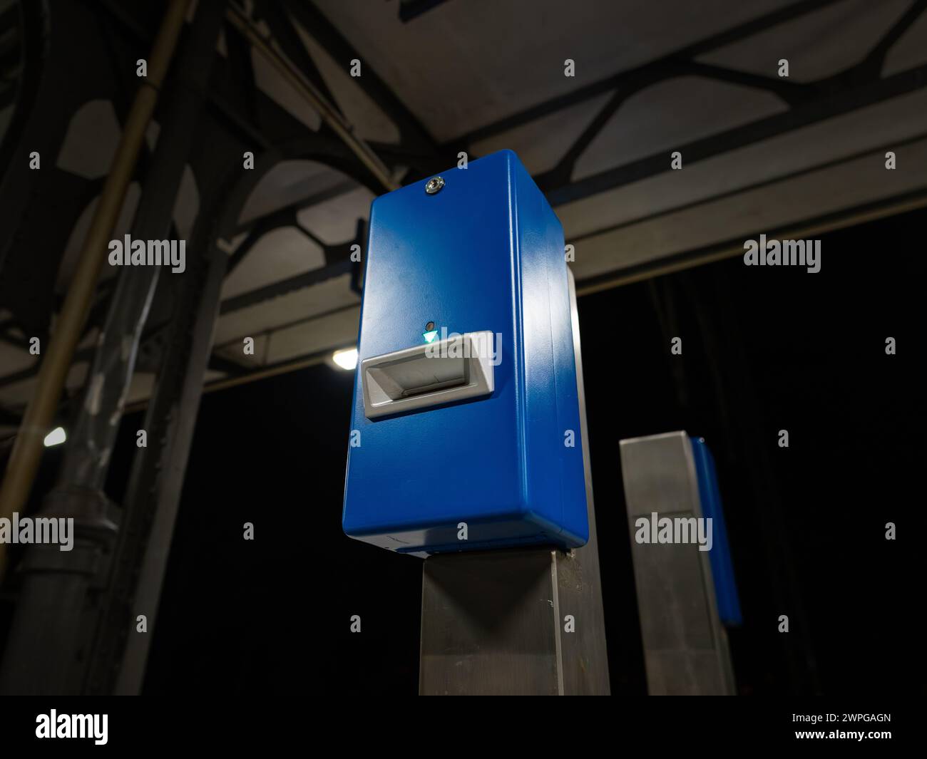 Am dunklen Bahnhof in der Nacht. Feld zur Validierung eines Fahrscheins für öffentliche Verkehrsmittel mit Stempel in Deutschland. Stockfoto