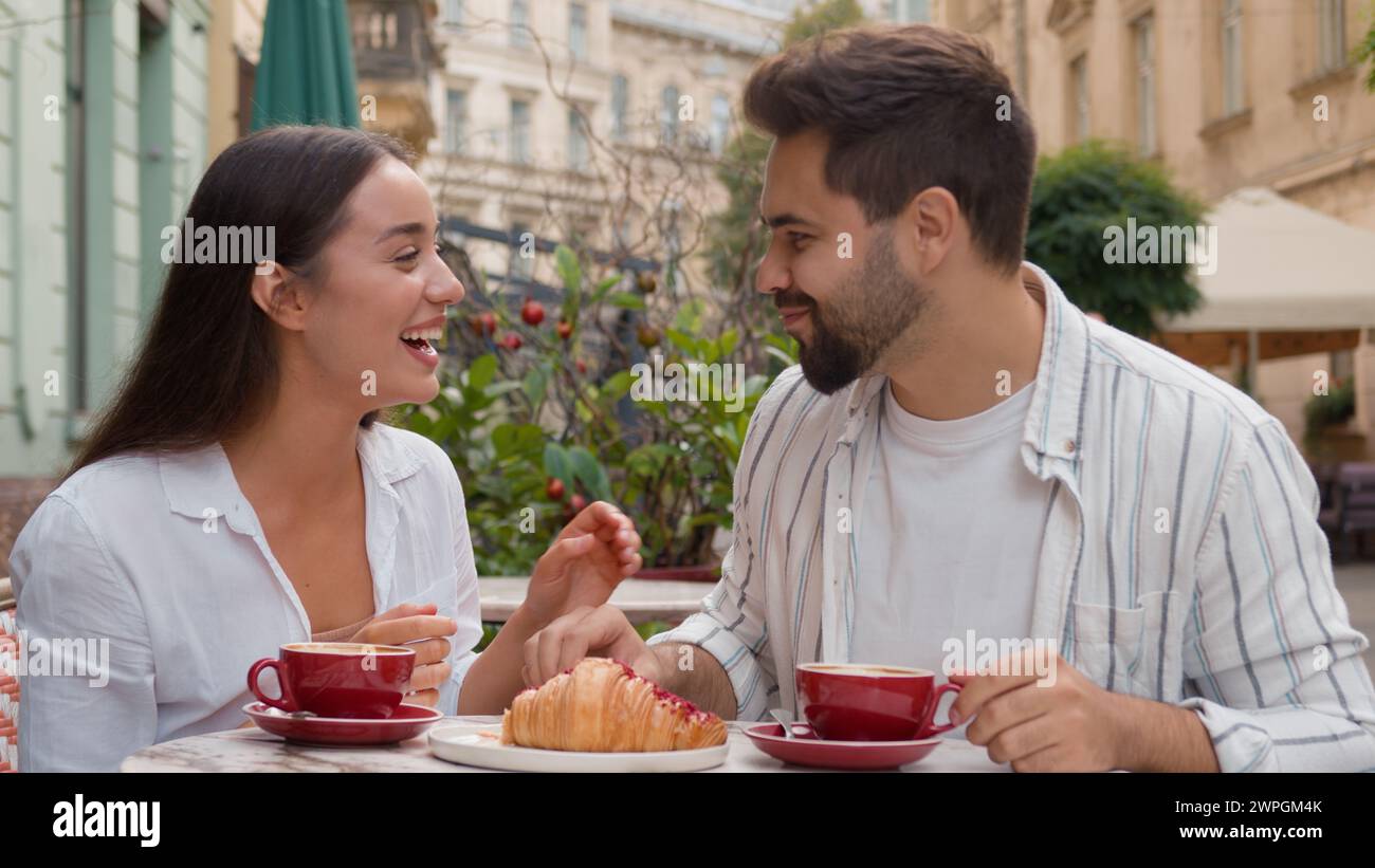 Kaukasische Freundin Fütterung Freund ein Croissant Mann Frau Paar glücklich Familie genießen Spaß Lächeln Lachen Stadt vor dem Frühstück Café Kaffee Stockfoto