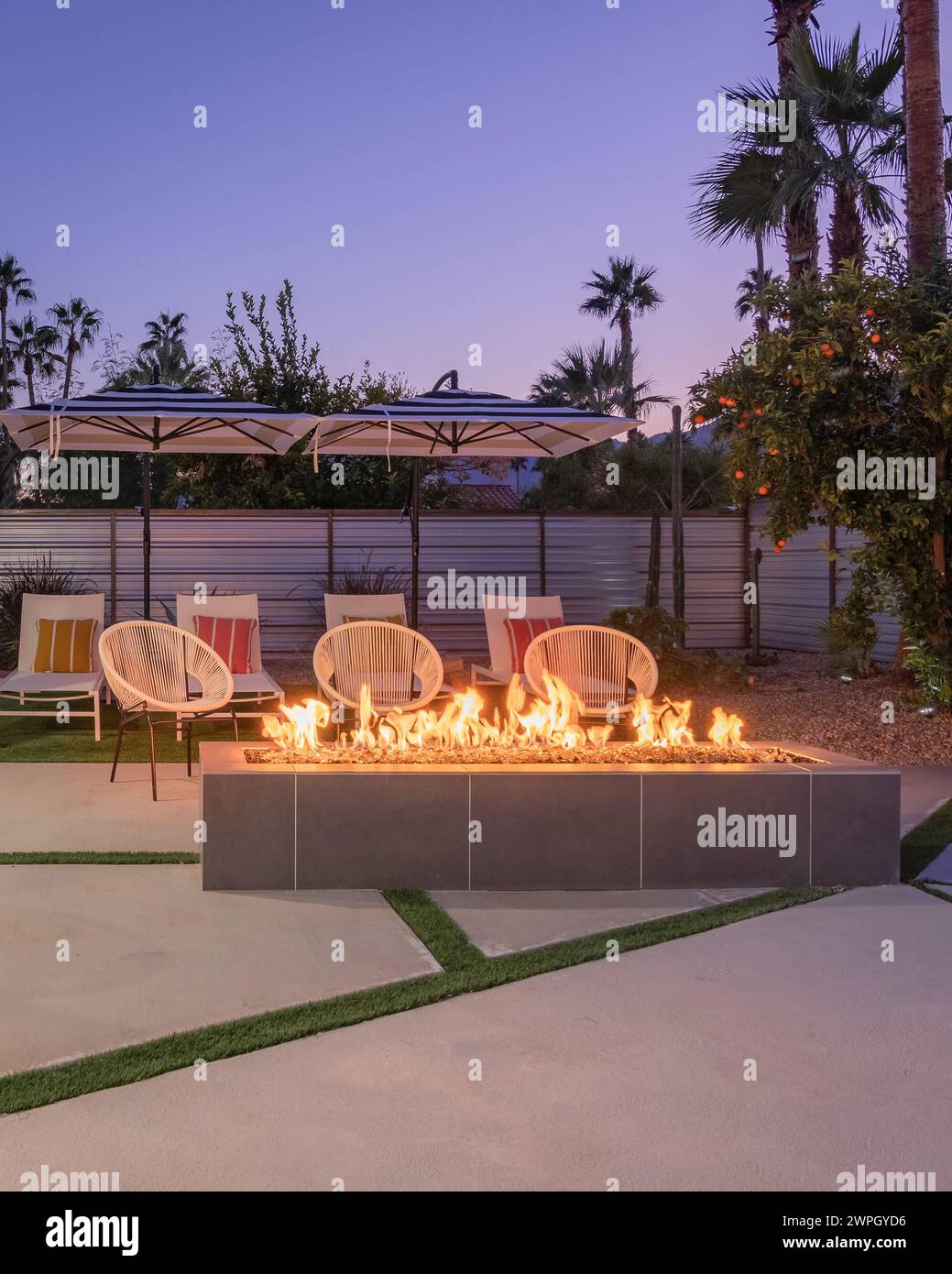 Hinterhof-Terrasse im Freien bei Nacht mit Kamin und Stühlen in Palm Springs, Kalifornien Stockfoto
