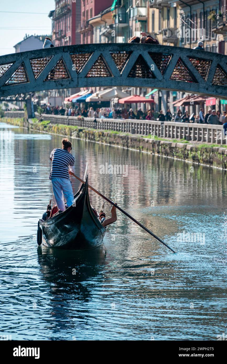 Gondelbahn und Gondoliere in der Darsena del Naviglio in Mailand, Italien. Navigierbarer Kanal und Navigationsmittel. Tourismus und Besuche in Mailand zu entdecken. Stockfoto