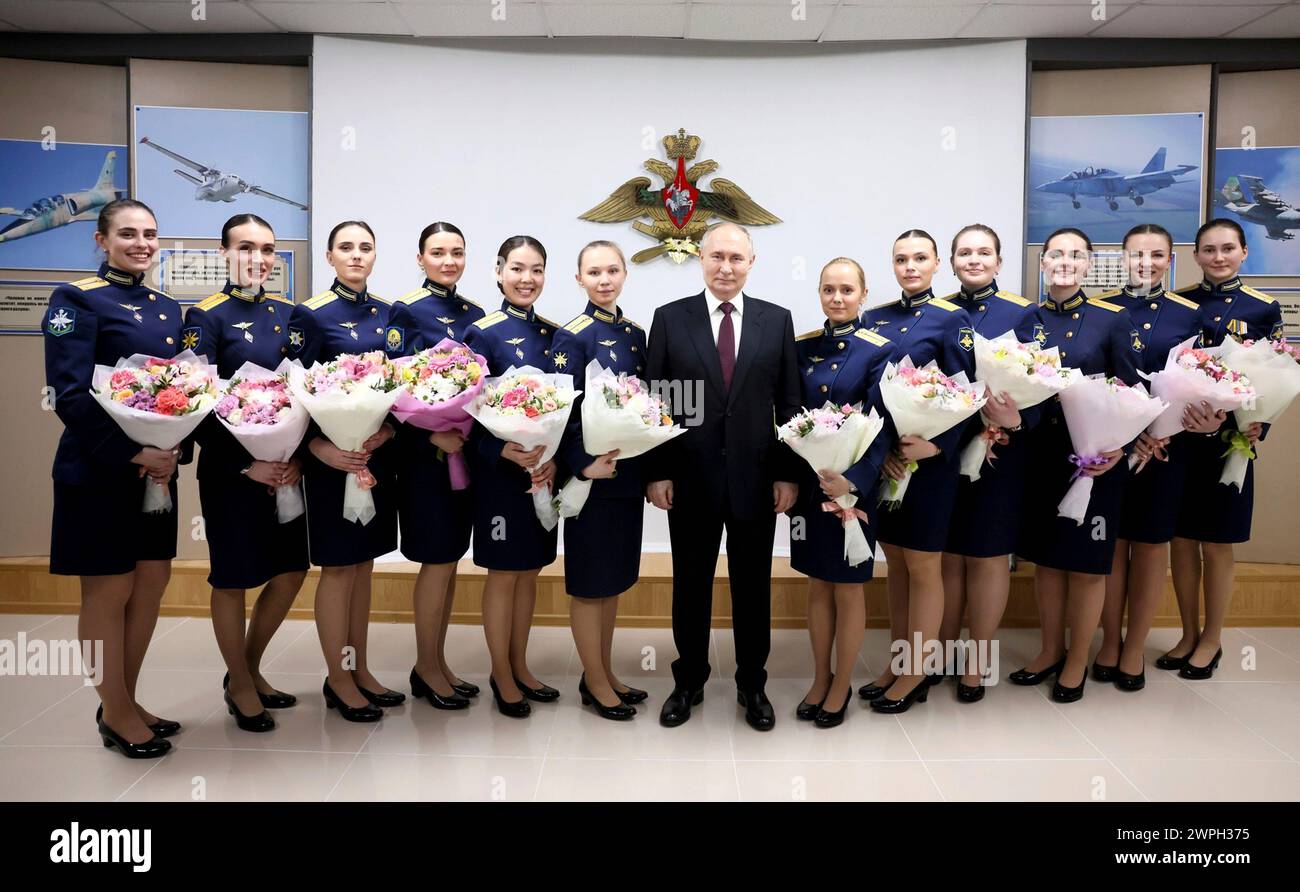 Krasnodar, Russland. März 2024. Der russische Präsident Wladimir Putin, Mitte, posiert mit Schülerinnen an der Anatoly Serov Krasnodar höheren Militärluftfahrt-Schule der Piloten, nachdem er ihnen am Vorabend des Internationalen Frauentages, 7. März 2024 in Krasnodar, Region Krasnodar, Russland, Blumen überreicht hat. Quelle: Mikhail Metzel/Kreml Pool/Alamy Live News Stockfoto