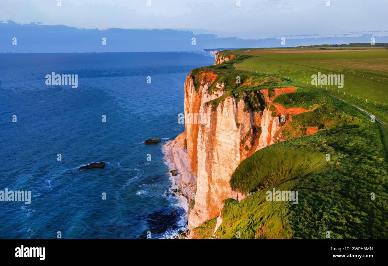 Berühmte normandische Küste im ausgezeichneten Dorf Etretat - jetzt fällt orange Sonnenuntergangslicht auf sie. (Seien Sie vorsichtig, jedes Jahr fallen mehrere Menschen herunter (tot) Stockfoto