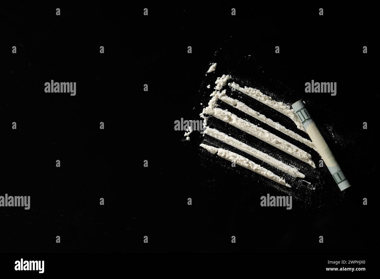 Harte Droge und gerollte Dollarscheine auf schwarzem Hintergrund, flache Lay. Leerzeichen für Text Stockfoto