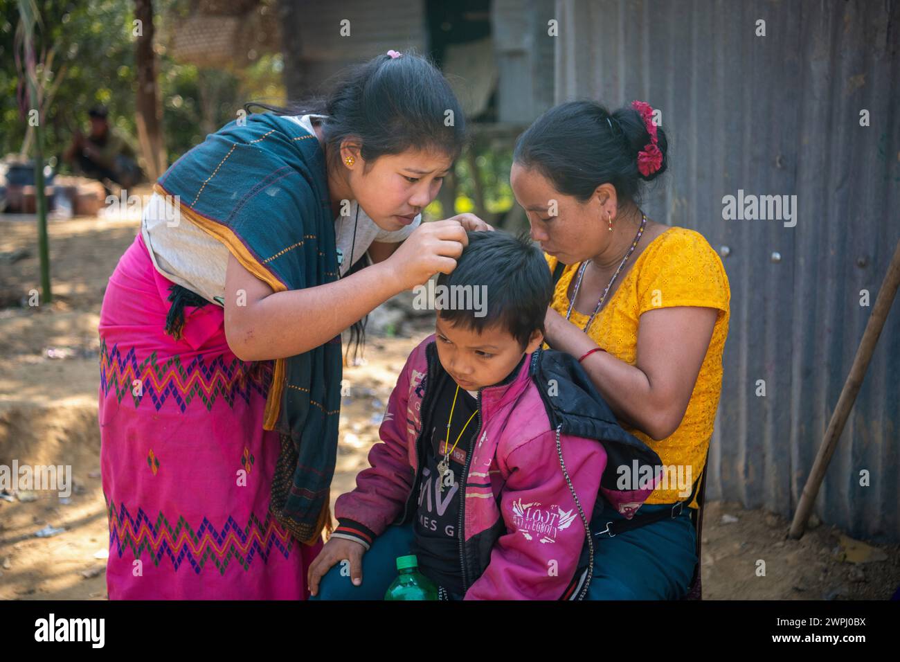 Zwei MRO-Frauen pflücken Läuse aus dem Kopf eines Kindes. MRO-Menschen sind eine indigene ethnische Gruppe in Bangladesch. Sie bewohnen hauptsächlich die Chittagong Hill Tracts (CHT) Region, die Distrikte wie Bandarban, Rangamati und Khagrachari umfasst. Die MRO-Völker sind eine der vielen indigenen Gemeinschaften in Bangladesch und haben eine eigene kulturelle Identität, Sprache und traditionelle Lebensweise. Stockfoto