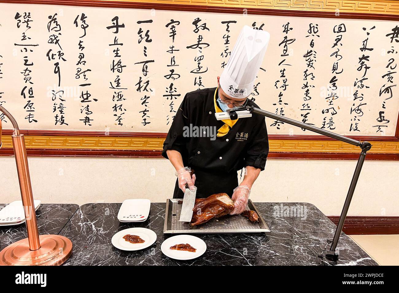 Peking, China. Dezember 2023. Am 9. Dezember 2023 bereitet ein Koch Entenbraten im Quanjude Roast Duck Restaurant in Peking, China, zu. Quanjude ist eine Restaurantkette, die für ihre Peking-Ente bekannt ist. (Foto: Samuel Rigelhaupt/SIPA USA) Credit: SIPA USA/Alamy Live News Stockfoto