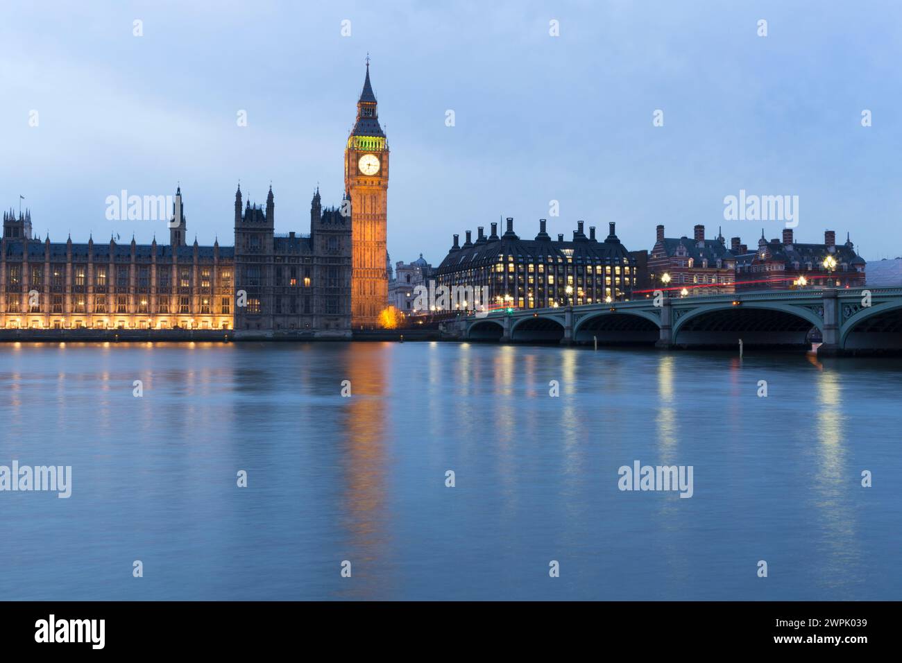 Großbritannien, London, die Houses of Parliament und die Westminster Bridge reflektieren in der Abenddämmerung. Stockfoto
