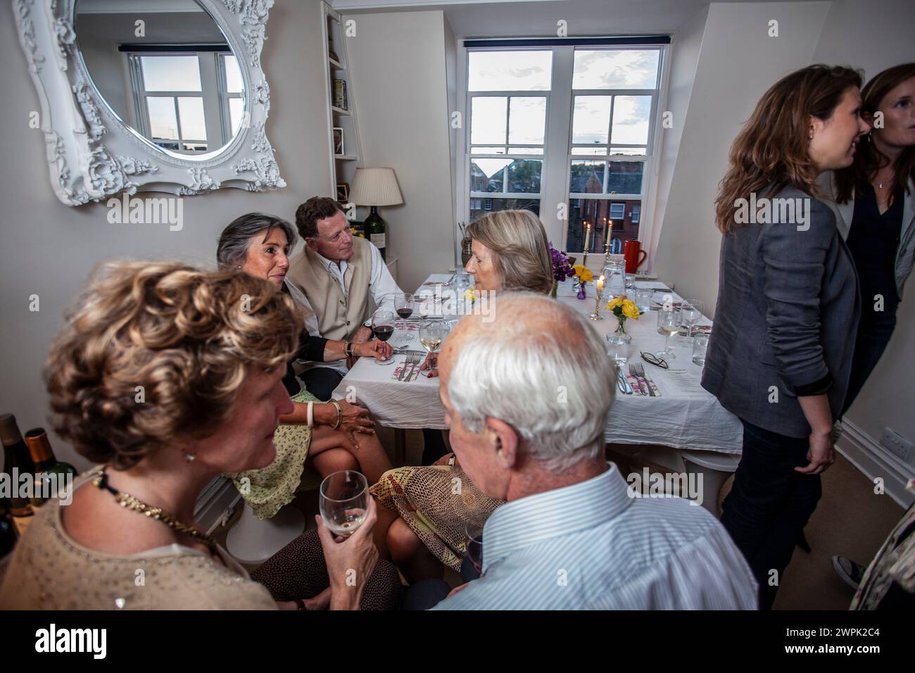 Eine Gruppe von Freunden, die in einem Londoner Apartment in den Noughern eine Dinnerparty feiern, mit Blick auf das Viertel im Südwesten Londons, England, Großbritannien Stockfoto