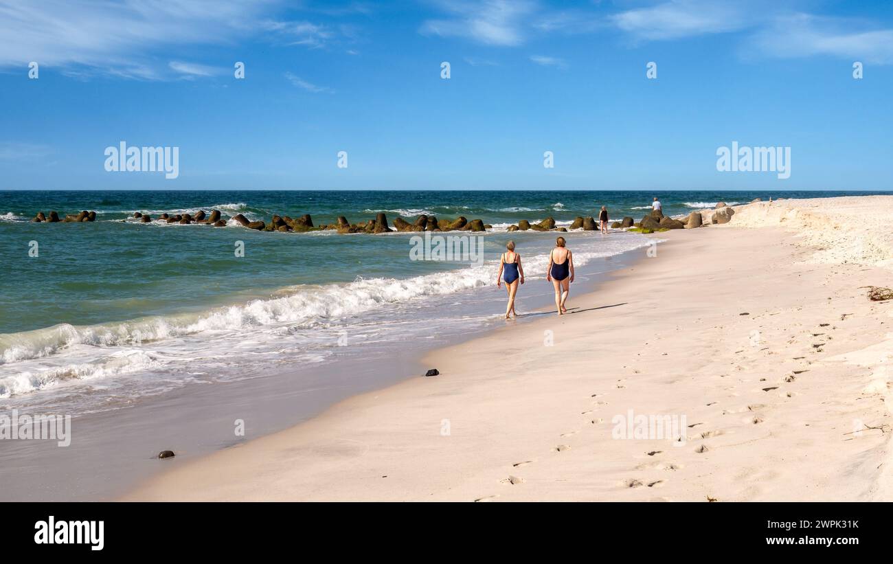 Zwei Frauen, die entlang der Wasserlinie am Strand Hoernum, Insel Sylt, Nordseeküste, Nordfriesland, Schleswig-Holstein, Deutschland Stockfoto
