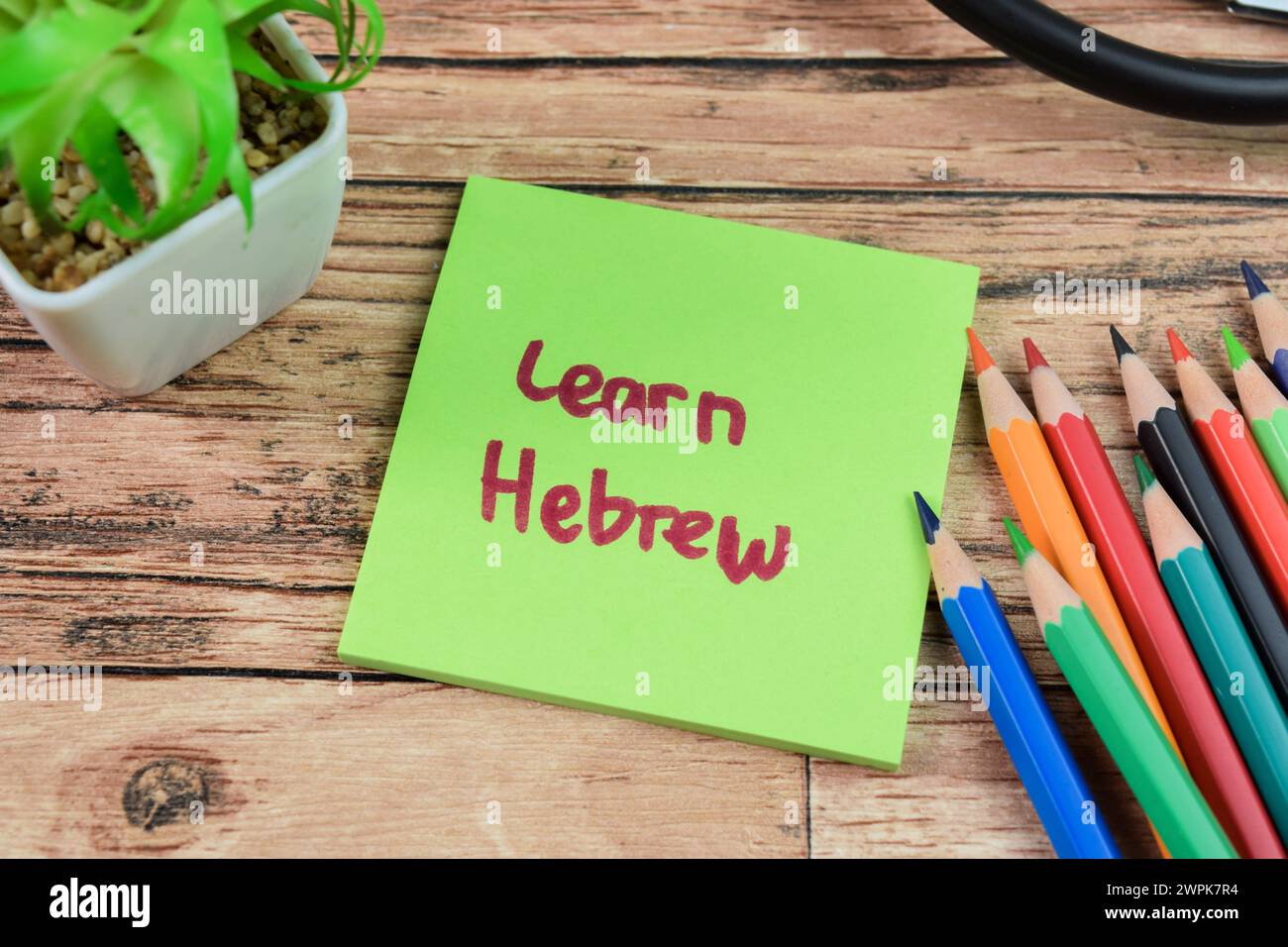 Konzept von Learn Herbrew Schreiben auf Haftnotizen isoliert auf Holztisch. Stockfoto