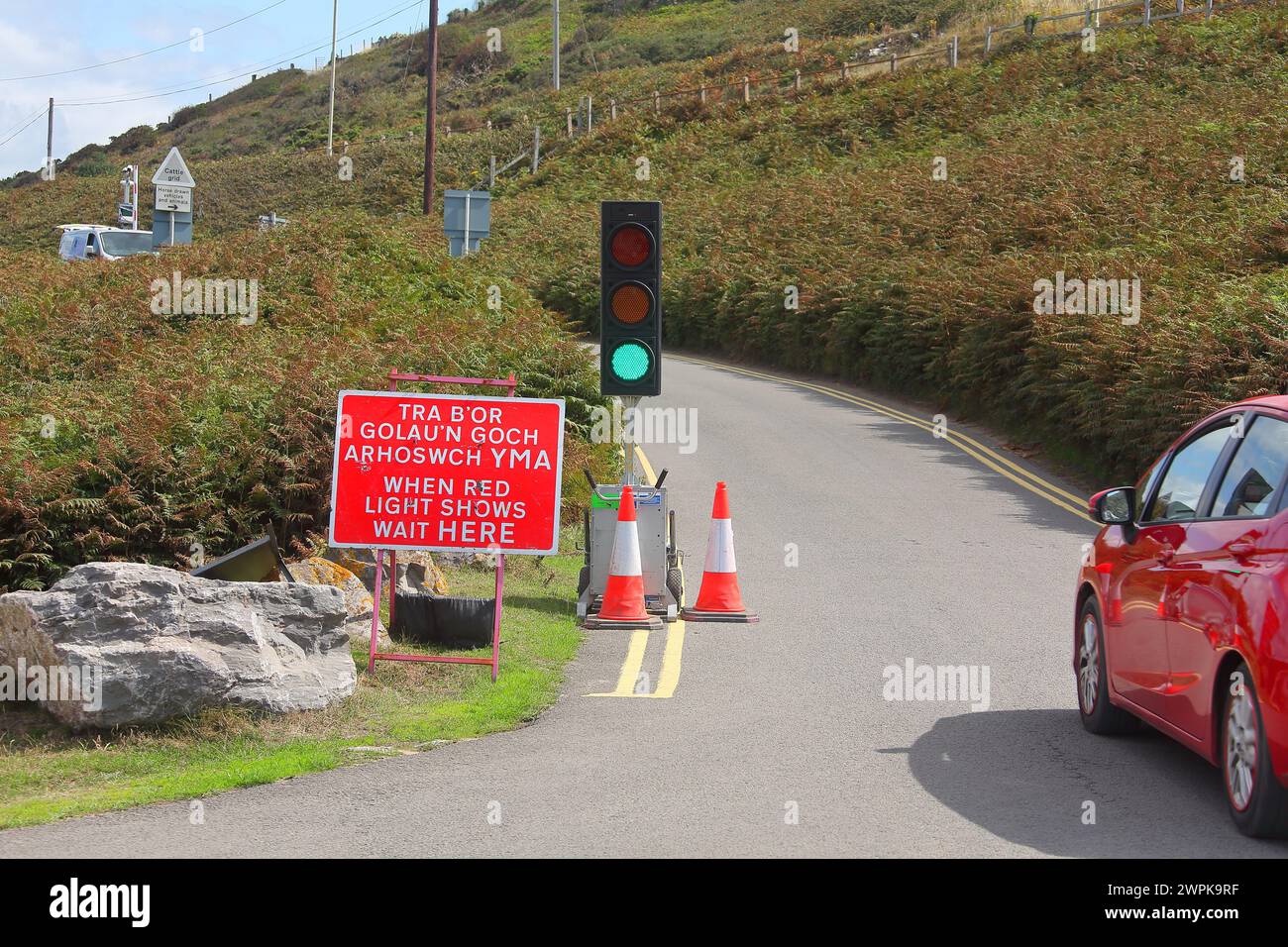 Automatische Verkehrssteuerung, die eine Richtung durch einige Straßenbauarbeiten am Eingang zu einem öffentlichen Parkplatz am Strand von Ogmore ermöglicht. Stockfoto