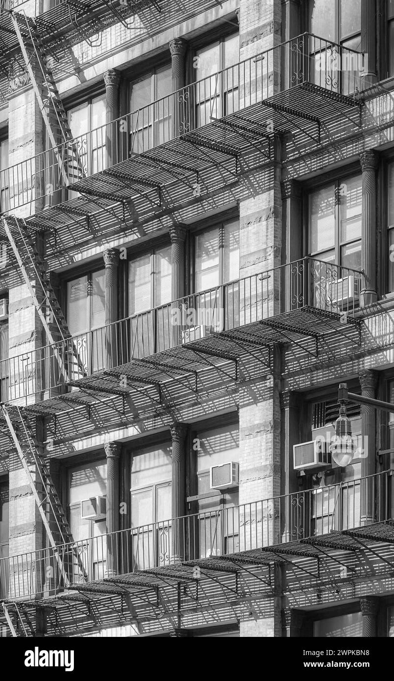 Schwarz-weiß-Foto eines alten Gebäudes mit Feuertreppe, New York City, USA. Stockfoto