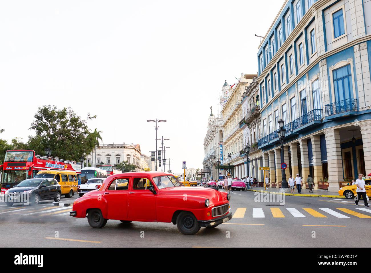 Red Cuban Car hebt sich von der lebhaften Havanna-Szene ab Stockfoto