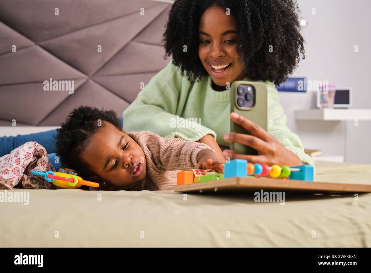 Kubanische Mutter macht ein Selfie, während sie mit ihrer Tochter spielt. Stockfoto