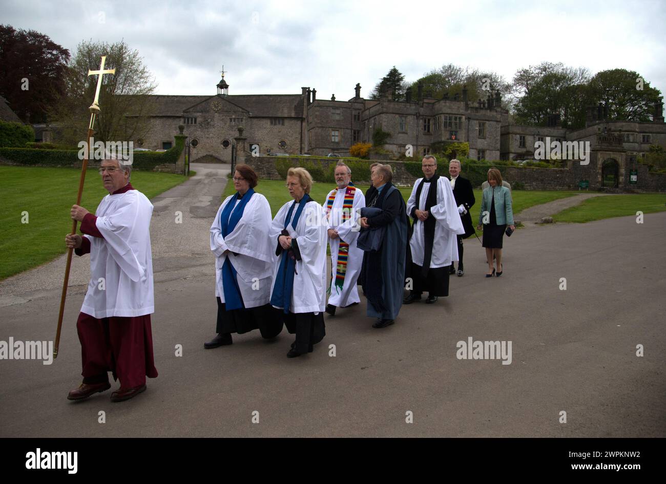 14/05/15 die Klerusmitglieder kommen an der Tissington Hall vorbei. Anlässlich des Aufstiegs werden die diesjährigen Well Dressings vom örtlichen Kreise enthüllt und gesegnet Stockfoto