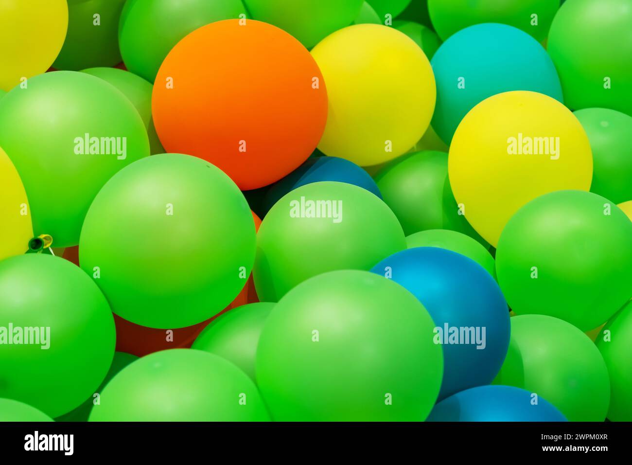 Aufblasbare Gummiballons aus grünem Gelb, orange, blauem Gummi. Stockfoto