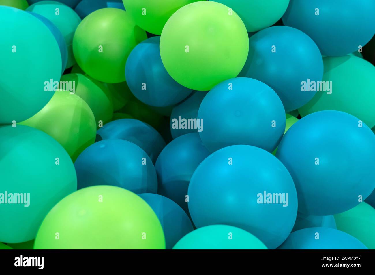 Aufblasbare Ballons aus grünem, blauem Gummi. Stockfoto