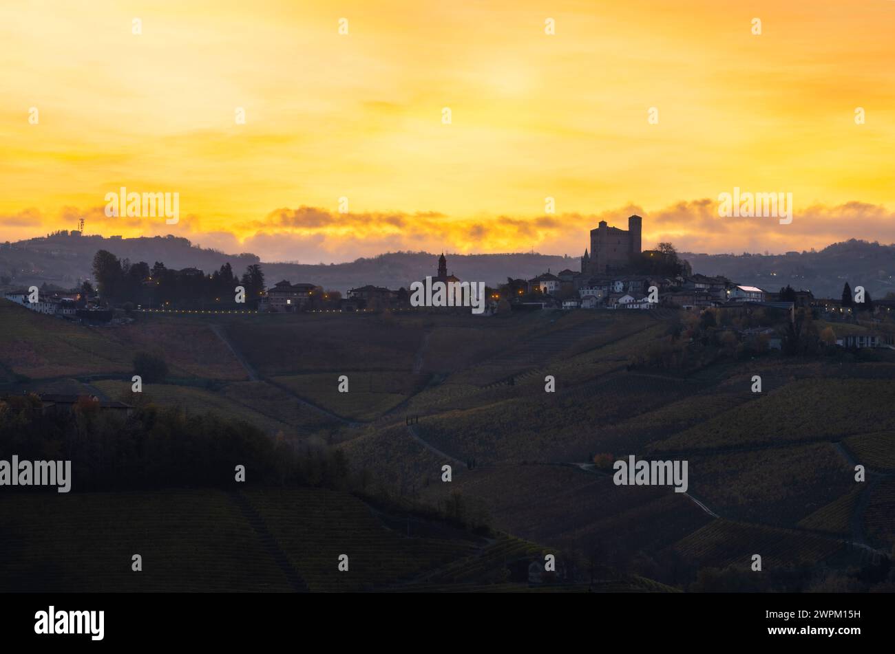 Serralunga d'Alba und seine Burg mit Weinbergen bei Sonnenaufgang im Hintergrund im Herbst, Cuneo, Langhe und Roero, Piemont, Italien, Europa Stockfoto