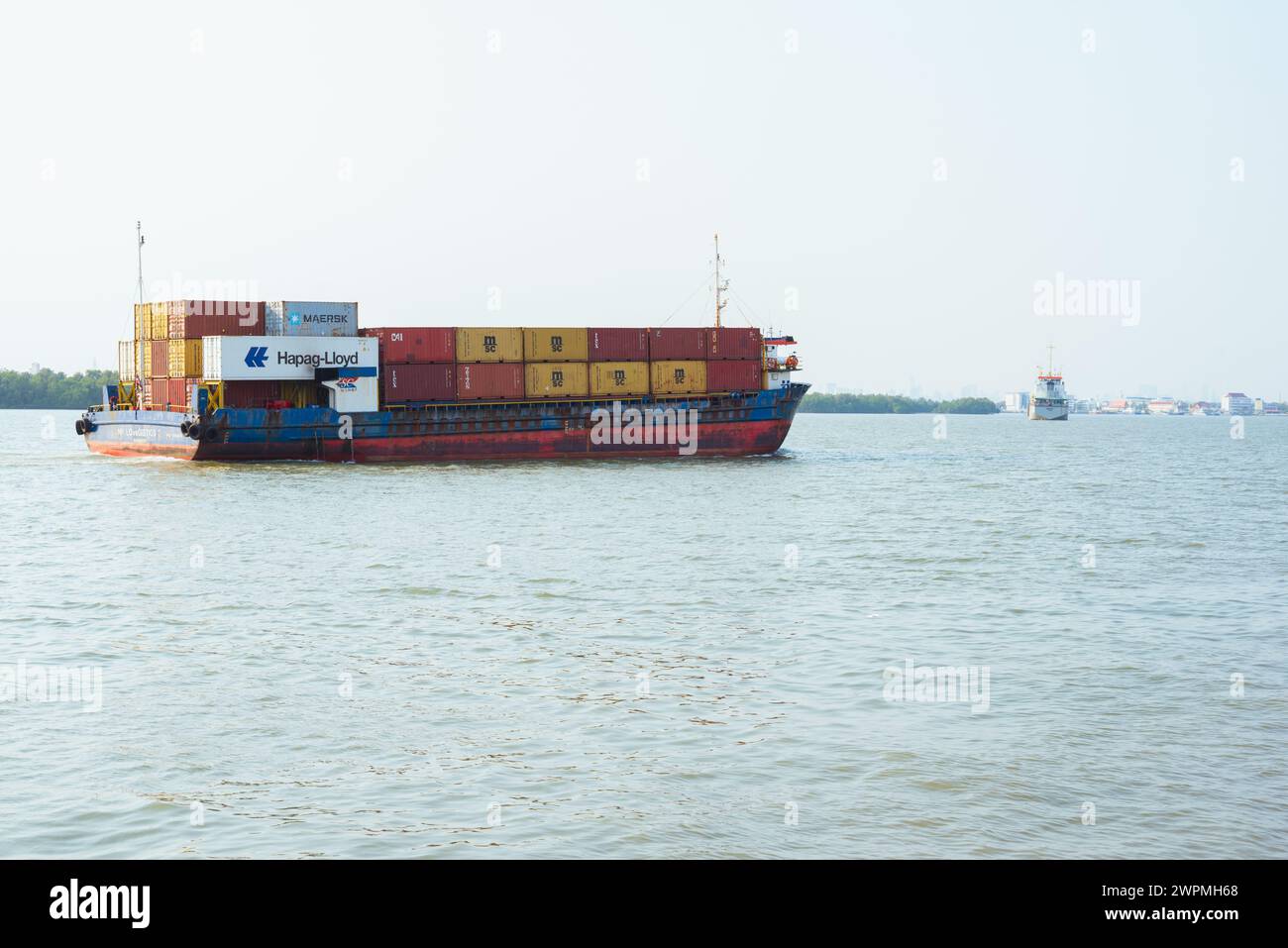 Das Containerschiff NP Lovegistics 2 mit Containern von Hapag-Lloyd, Maersk, MSC und anderen fährt am 1. März 2024 in Samut Prakan entlang des Chao Phraya River Stockfoto
