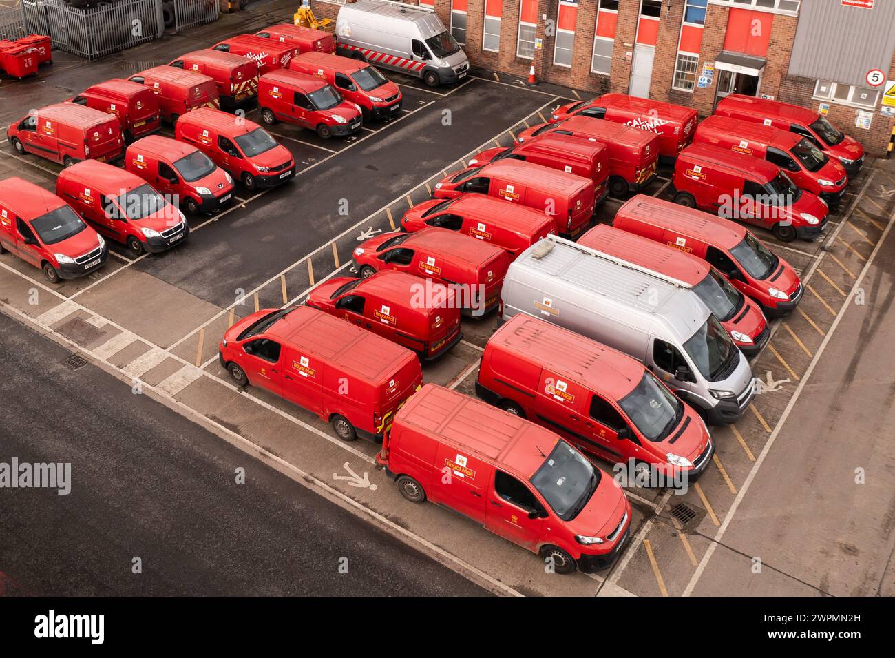 LEEDS, GROSSBRITANNIEN - 16. FEBRUAR 2024. Luftaufnahme einer Flotte geparkter Poststellen Fahrzeuge an einem Depot aus der Luft Stockfoto