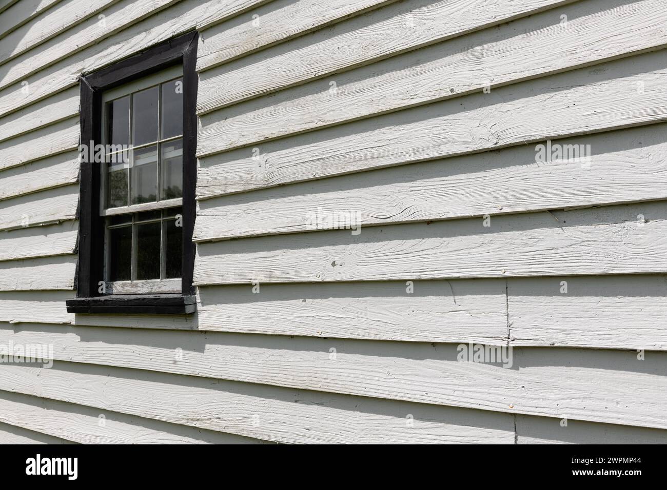 Aufbau eines Fensters auf einem alten Holzgebäude. Stockfoto