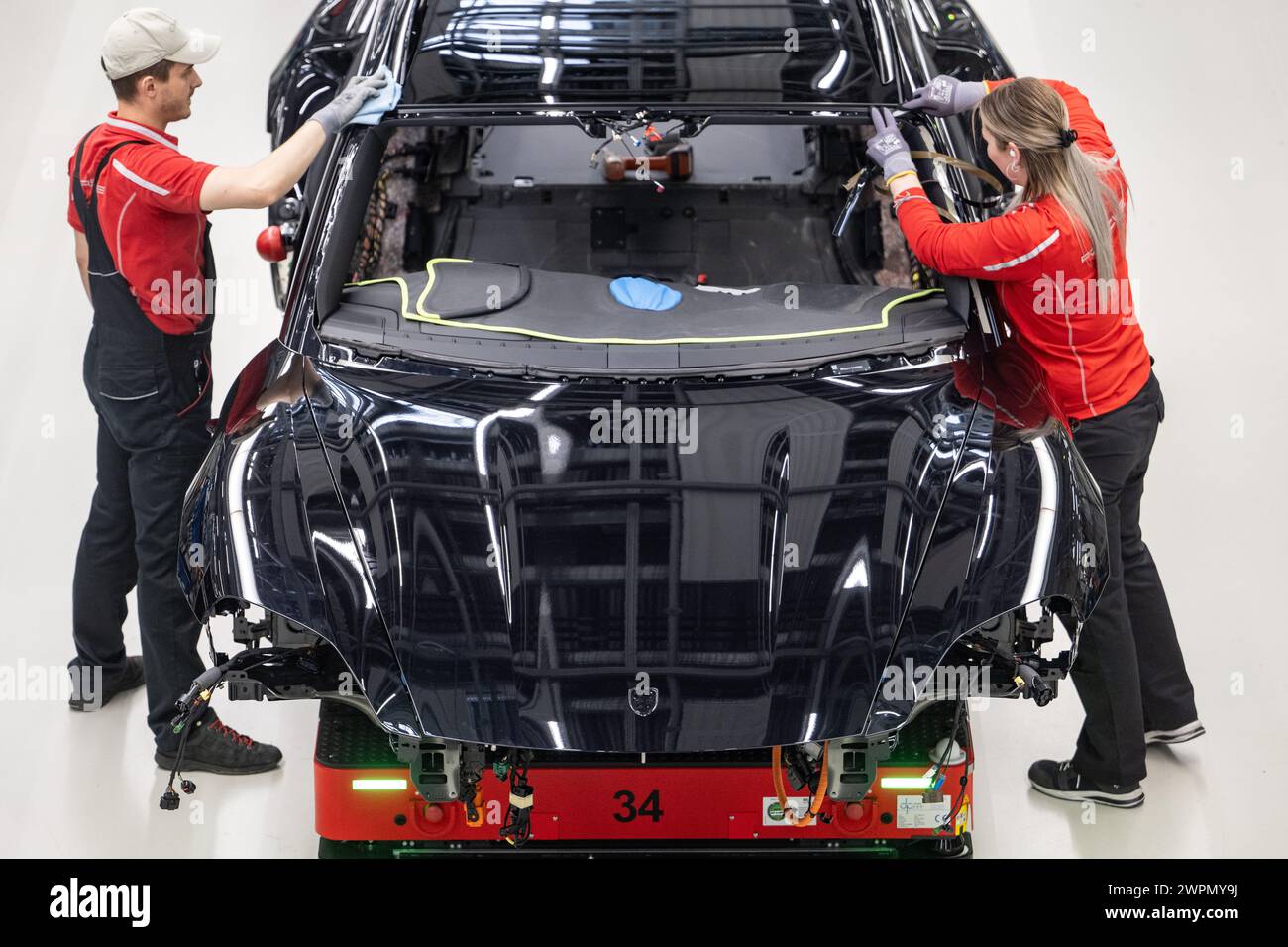 Stuttgart, Deutschland. März 2024. Mitarbeiter der Porsche AG bauen im Hauptwerk Zuffenhausen einen vollelektrischen Porsche Taycan zusammen. Quelle: Marijan Murat/dpa/Alamy Live News Stockfoto