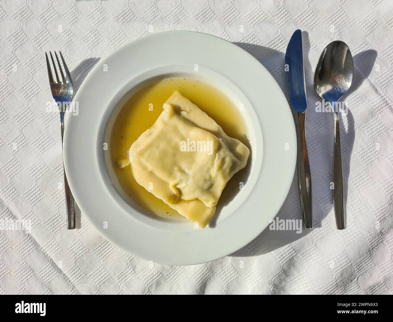 Spezialität: Schwäbische Pasta-Quadrate in Gemüsebrühe, serviert als warme Mahlzeit auf einem tiefen Suppenteller Stockfoto