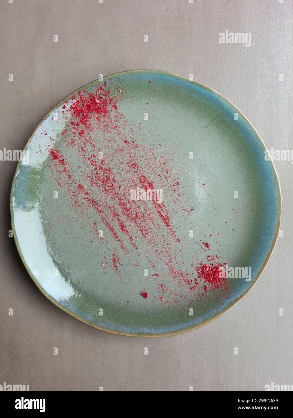 Eine grüne Platte mit trockenen roten Pigmenten getrockneter Himbeeren Stockfoto