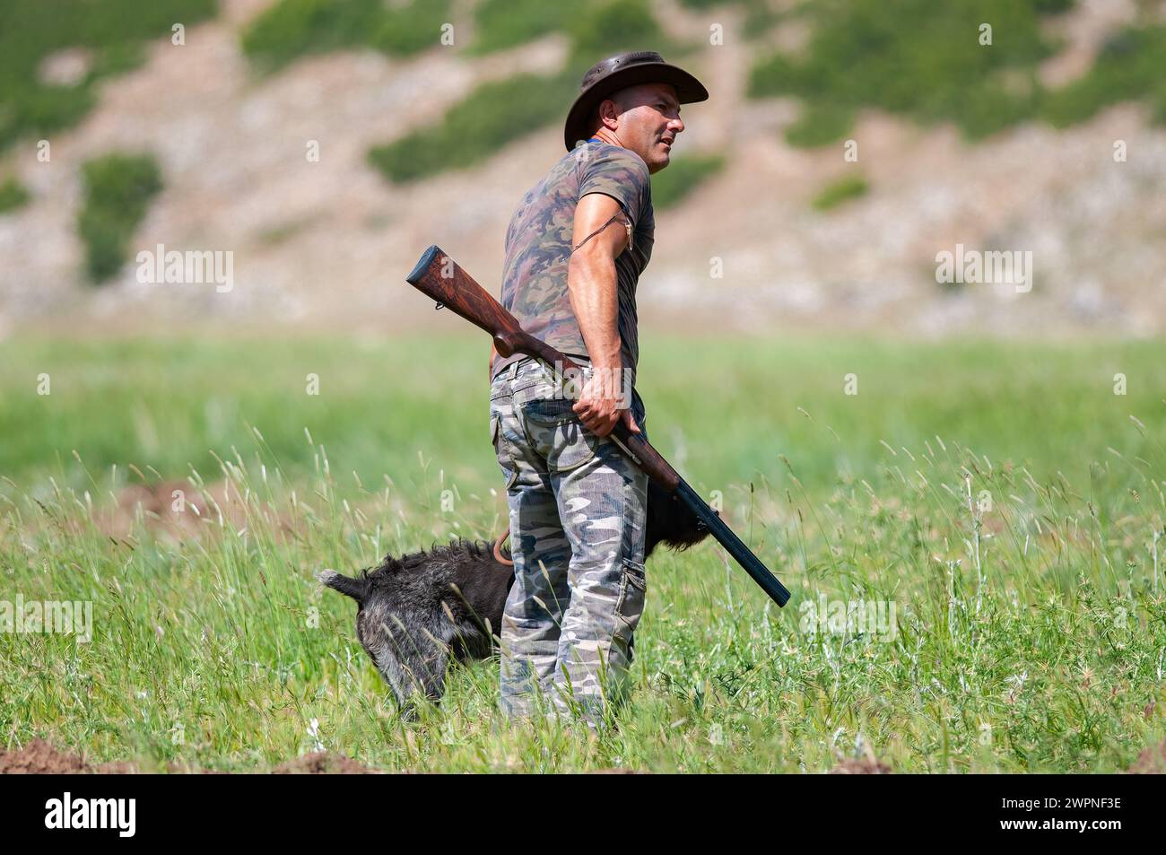 Der Jäger verfolgt seine Beute mit seiner Waffe und seinem Hund. Stockfoto