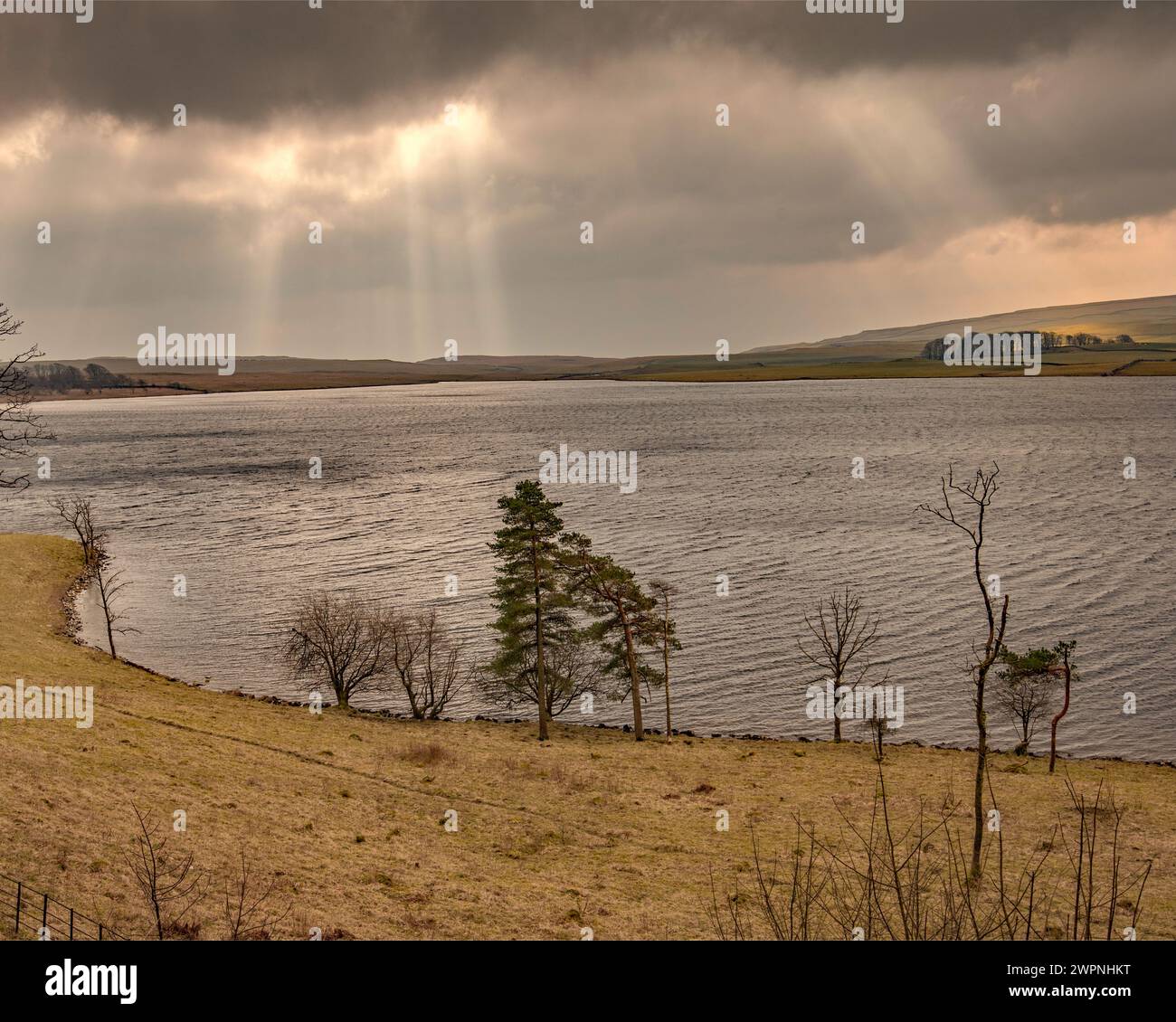 Ein kleines Licht, das durch dunkle Wolken über Malham Tarn im Yorkshire Dales National Park bricht. (National Trust). Stockfoto