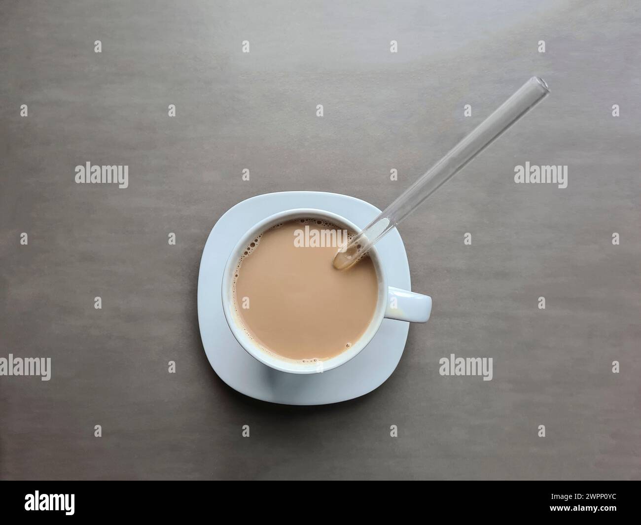 Latte in einer weißen Tasse mit Glasstroh Stockfoto