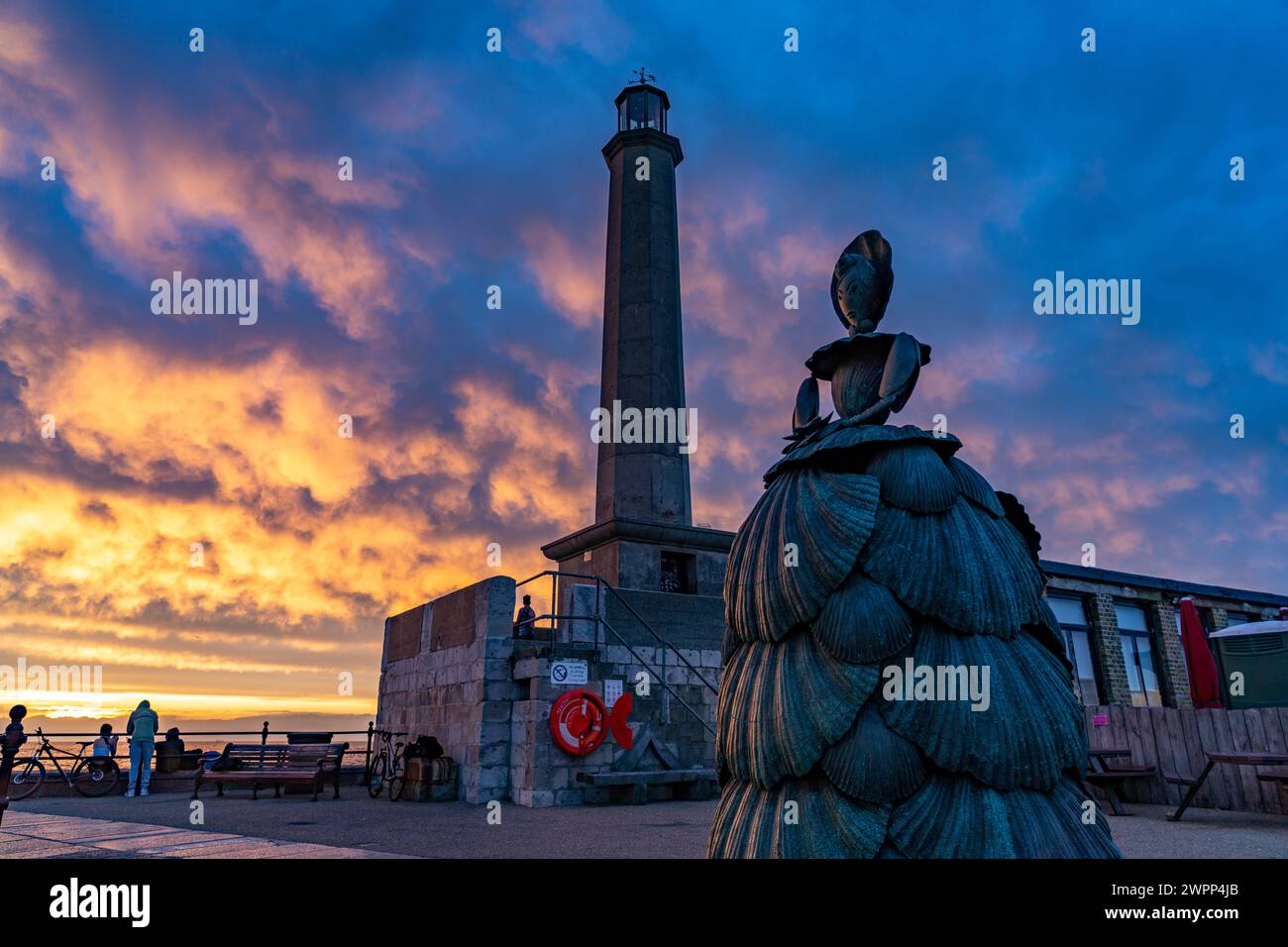 Bronzeskulptur Mrs. Booth die Shell Lady und der Margate Lighthouse bei Sonnenuntergang, Kent, England, Großbritannien, Europa Stockfoto