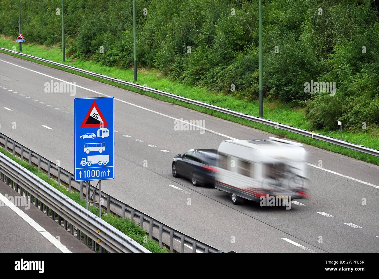 Auto mit Wohnmobil fährt auf der Autobahn mit einer Steigung von 8 % Stockfoto