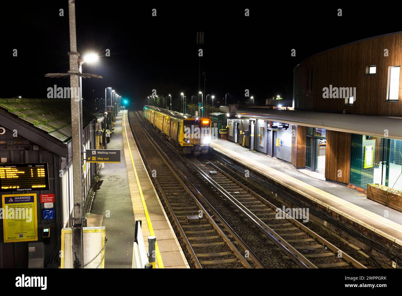Merseyrail Electrics Class 507 Third Rail Electric Train 507017 am Bahnhof Ainsdale, Southport, UK bei Nacht Stockfoto