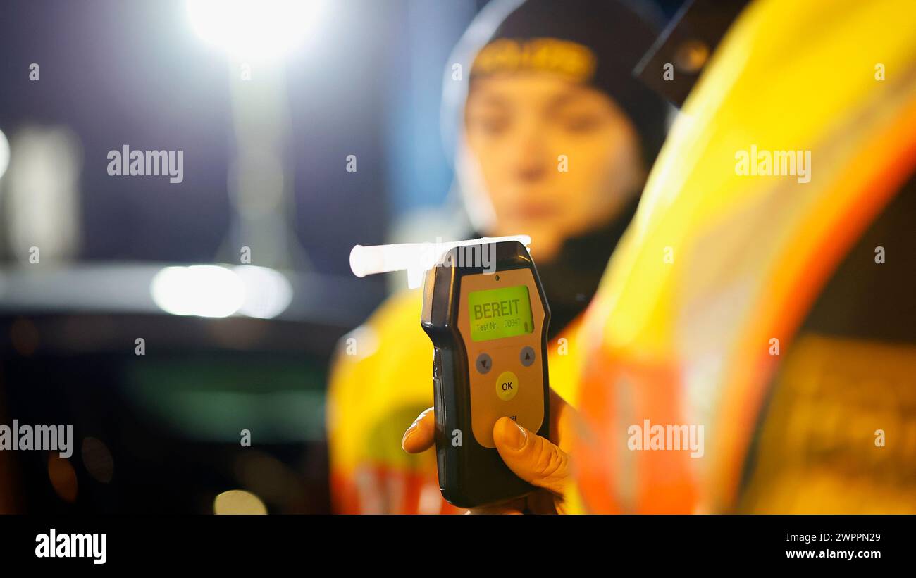 Aschaffenburg, Deutschland. März 2024. Eine Polizistin misst den Atemalkoholgehalt eines Fahrers mit einem Atemgerät, um festzustellen, ob er möglicherweise unter Alkoholeinfluss steht. Hinweis: Heiko Becker/dpa - ACHTUNG: Person(en) wurde/wurden aus rechtlichen Gründen pixeliert/dpa/Alamy Live News Stockfoto