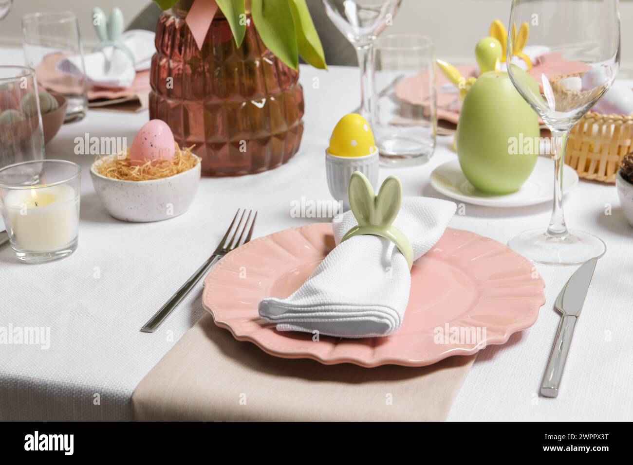 Festliche Tischauflage mit Serviettenring in Form von Hasenohren. Osterfeier Stockfoto