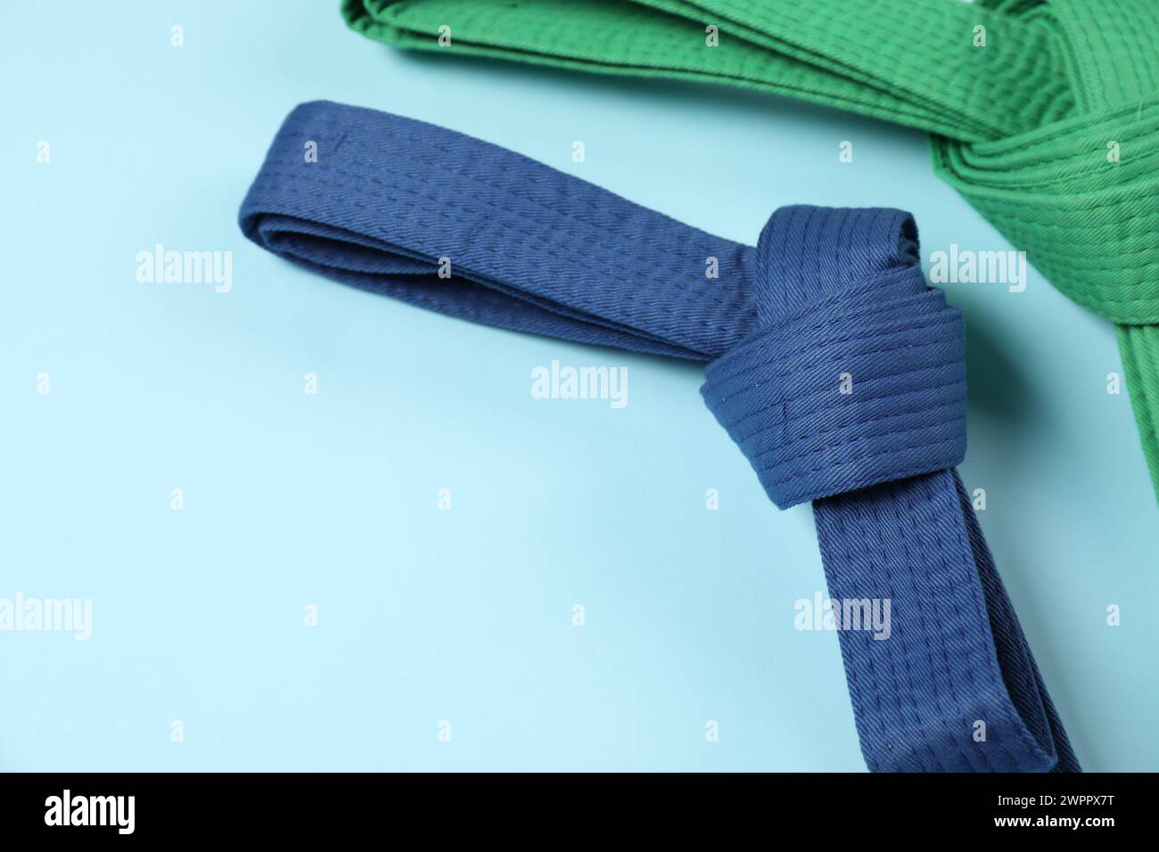 Bunte Karategürtel auf hellblauem Hintergrund, Platz für Text Stockfoto