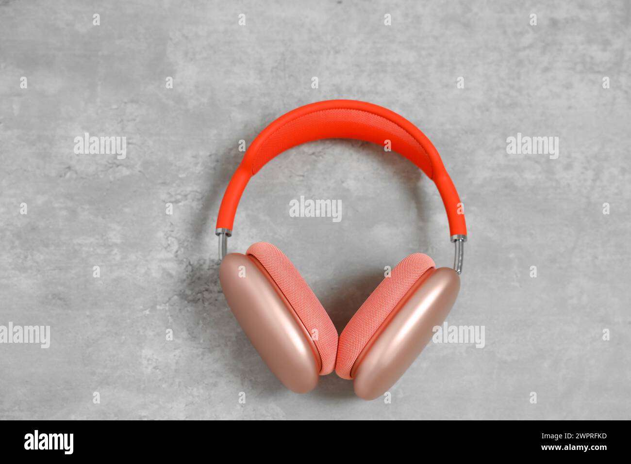 Elegante pinkfarbene Kopfhörer auf hellgrauem Tisch, Draufsicht Stockfoto