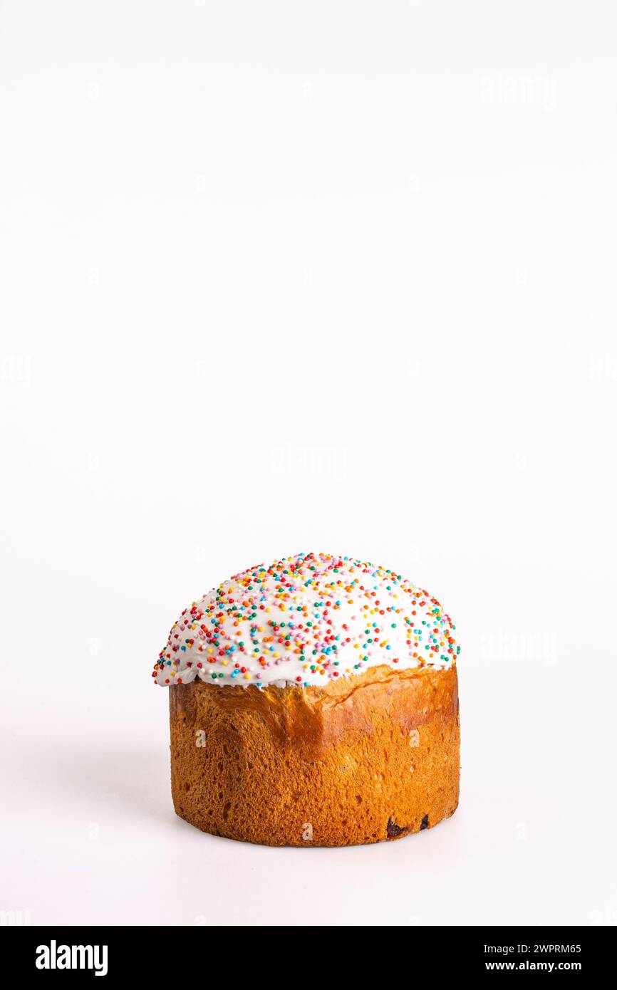 Kulich ist ein russisches Osterbrot mit süßem Hefeteig, Rosinen, getrockneten Früchten, weißer Glasur und bunten Streuseln. Traditionelles festliches Vergnügen. Stockfoto