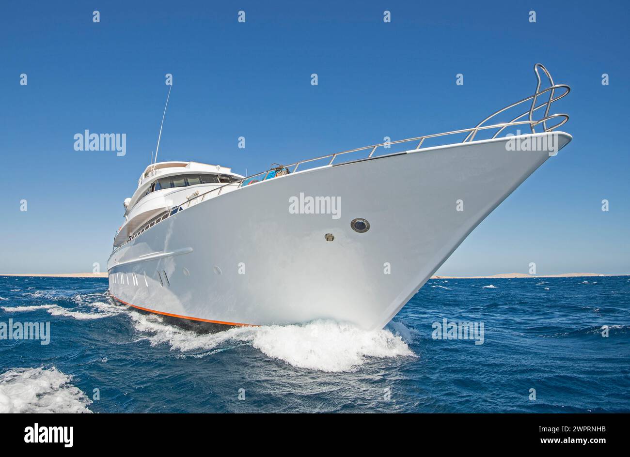 Eine große private Luxusmotoryacht, die auf tropischem Meer mit Bugwelle segelt Stockfoto