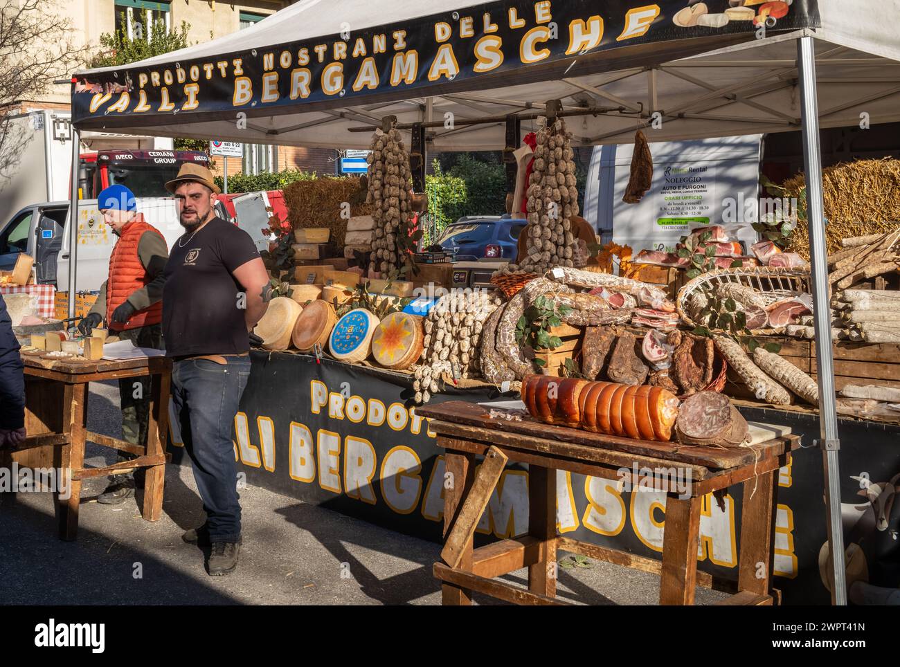 Ein italienischer Mann mit seiner Tradition Käse, Wurstwaren und Trockenfleisch Stand, Fauche Markt, ein großer Freiluftmarkt in Mailand, Italien. Stockfoto